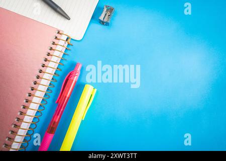 Verschiedene Arten von Schul-/Bürobedarf zum Lernen, auf blauem Hintergrund. Zurück zur Schule. Stockfoto