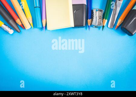 Verschiedene Arten von Schul-/Bürobedarf zum Lernen, auf blauem Hintergrund. Zurück zur Schule. Stockfoto