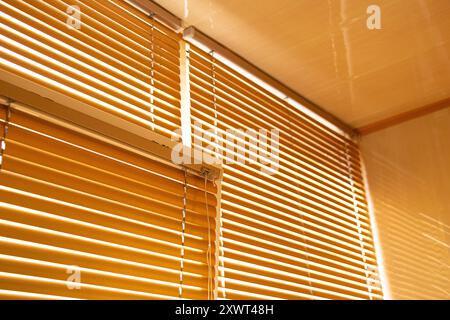 Gelbe Jalousien am Fenster in der Wohnung während des Tages Nahaufnahme Stockfoto