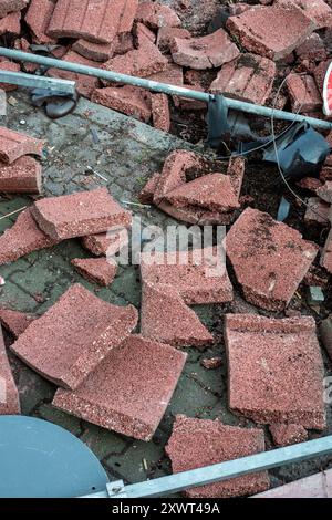 Eine Nahaufnahme von gebrochenen roten Ziegeln und Schutt, die auf dem Boden verstreut sind. Das Bild kann Zerstörung, Chaos und Zusammenbruch symbolisieren und die Fragilität von Strukturen und Plänen im Leben repräsentieren. Stockfoto