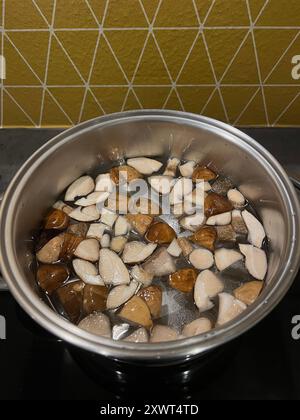Gehackte Wildpilze werden in einer Pfanne in der Küche gekocht. Stockfoto