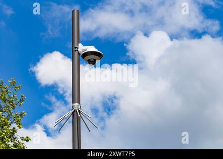 Überwachungskamera an einem Lichtmast auf der Straße. Sicherheitskamera und Stadtvideo vor blauem Himmel. Videoüberwachungskameras für den Außenbereich. Stockfoto