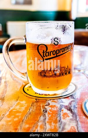Pint Glas auf Holztisch mit staropramen Lagerbier im britischen Pub uk Stockfoto