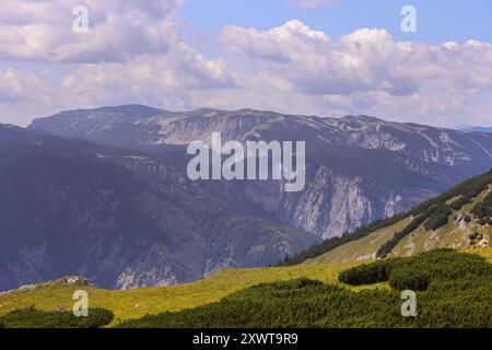 Ein Panoramablick vom Schneeberg-Plateau in Österreich, der das raue Gelände des Rax-Gebirges zeigt. Die Szene fängt einen Kontrast zwischen den Kulissen ein Stockfoto