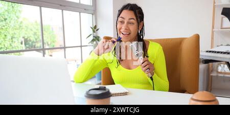 Junge afroamerikanische Frau mit Mikrofon-Podcast im Studio Stockfoto