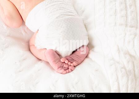 Neugeborenes im Krankenhauszimmer. Nahaufnahme der Babyfüße. Neugeborenes Kind in hölzernen Mitschlafkrippe. Kleinkind, das in der Bettwanne schläft. Niedlicher winziger Fuß. Stockfoto