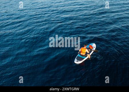 Aus der Vogelperspektive auf dem SUP, umgeben von dem atemberaubenden Blau des azurblauen Meeres Stockfoto