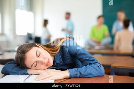 Müde junge Frau schlief bei einer Vorlesung im Auditorium ein Stockfoto