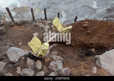 Eingekreist von einer zerfurchten Felswand liegt im Krater des Gunung Iljen der Kratersee. Seine grünlich-blaue Farbe ist auf hohe Konzentrationen von Alaun, Schwefel und Gips zurückzuführen. Mit einem pH-Wert um 0,3 und seiner wird er als größtes Säurefass der Erde bezeichnet. Seit der Kolonialzeit wird an so genannten Solfataren am Südostufer des Kratersees Schwefel abgebaut. Keramikrohre leitet das oxidierende mit Wasserdampf vermischte Gas von der Austrittsstelle weg, wodurch es abkühlt, sich anreichert und in gelben Brocken abtransportiert wird. Kratersee - Breite: 600 m - Länge: 960 m - Stockfoto