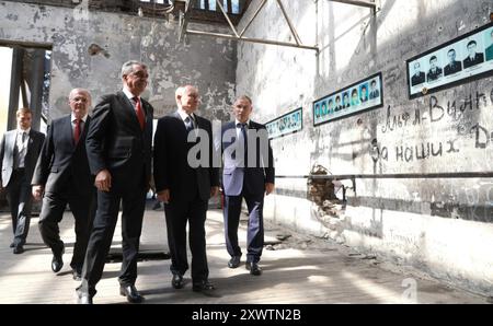 Beslan, Russland. August 2024. Der russische Präsident Wladimir Putin, Mitte, begleitet von Nordossetien-Alania-Chef Sergej Menyailo, 2. Links, und dem nordkaukasischen Bundesbezirksgesandten Juri Chaika, besucht die ehemalige Beslan-Schule Nr. 1 am 20. August 2024 in Beslan, Republik Nordossetien-Alanien, Russland. Die Schule ist der Ort der tödlichsten Schulschießerei in der Geschichte, die mit dem Tod von 334 Menschen endete. Quelle: Vyacheslav Prokofyev/Kreml Pool/Alamy Live News Stockfoto