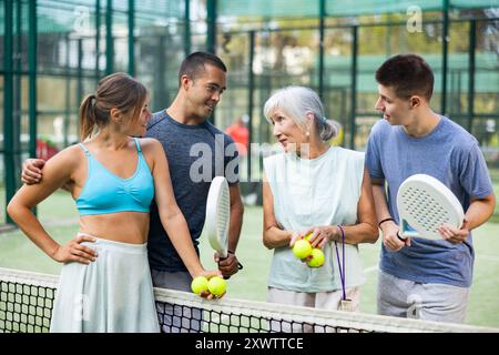 Zwei Padel-Spieler diskutieren auf einem offenen Platz glücklich über das vergangene Spiel Stockfoto