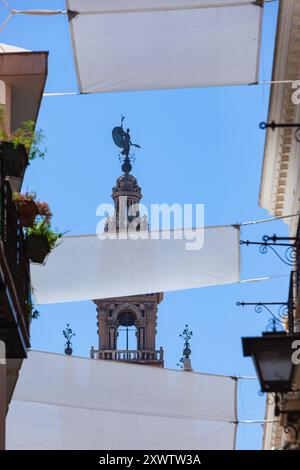 El Giraldillo, die Statue auf der Spitze der Giralda, der Glockenturm der berühmten Kathedrale von Sevilla von der Straße aus gesehen, Andalusien, Spanien Stockfoto