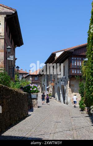 Eine kopfsteingepflasterte Straße, die sich mit typischen Häusern in der malerischen und historischen Stadt Santillana del Mar in Kantabrien, Spanien, aneinanderreiht. Stockfoto