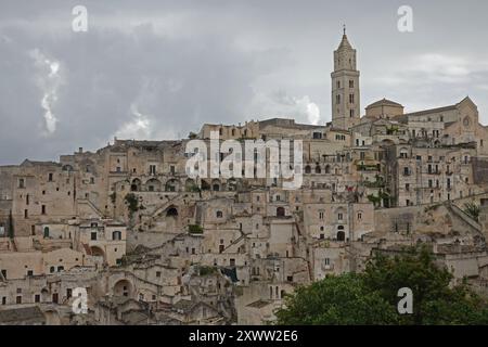 Der Abschnitt „Sassi“ von Matera in Süditalien wird bei bewölktem Tag in einer weiten Ansicht gezeigt. Die Höhlenhäuser an den Klippen dieser alten Zeit Stockfoto