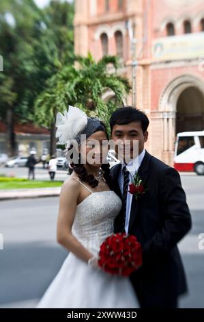 Jungvermählte in einem Fotoshooting vor der Kathedrale Notre Dame in Saigon, Vietnam. Stockfoto