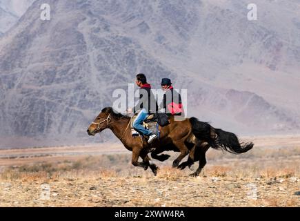 Kasachische Adlerjäger treten beim Tiyn Teru - Münzabholer-Pferderennen in der Region Altai in der Westmongolei an. Stockfoto