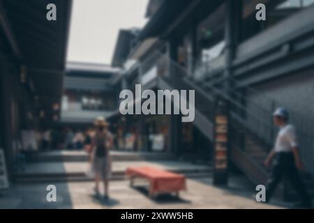 Ein verschwommener Blick auf einen Fußgängerweg in Japan mit einem roten Tisch und vorbeigehenden Leuten. Stockfoto