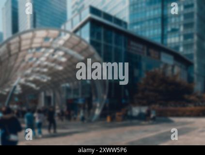Ein verschwommenes Bild einer Straßenszene in Shenzhen, China. Der Hintergrund zeigt hohe Gebäude und Bokeh-Effekte, während eine Gruppe von Menschen in der Flucht läuft Stockfoto