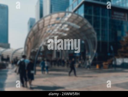 Ein verschwommener Blick auf Fußgänger, die durch ein Stadtgebiet in Shenzhen, China, laufen. Die Szene zeigt einen Metallsteg mit Bokeh-Hintergrund. Stockfoto