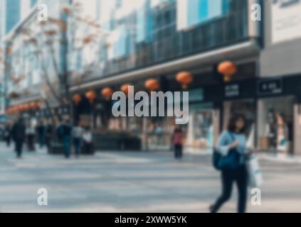 Ein verschwommener Blick auf eine geschäftige Straße in Shenzhen, China, mit roten Laternen über den Geschäften und einem Bokeh-Hintergrund. Stockfoto