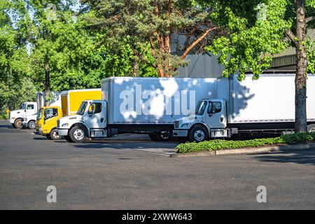 Mittelschwere industrielle Standard-Lkw mit weißem Tagfahrerhaus Auflieger und Kastenanhänger für lokale Lieferungen und kleine Unternehmen stehen auf der breiten Wa Stockfoto