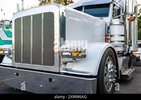 Eleganter industrieller weißer Träger klassischer großer Auflieger mit Auflieger auf Treppendeck stehend zum Ausruhen auf dem Parkplatz des LKW zur Dämmerung t Stockfoto