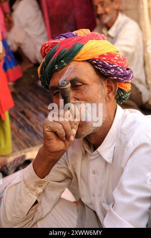 Ein Rajasthani-Mann raucht die traditionelle Chillum-Pfeife. Foto gemacht in Nagaur, Rajasthan, Indien. Stockfoto