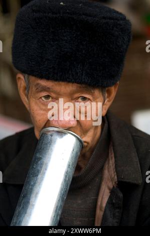 Nachmittags Rauch mit einer Metallpfeife. Foto auf dem Laomeng Wochenmarkt in der südlichen Provinz Yunnan, China. Stockfoto