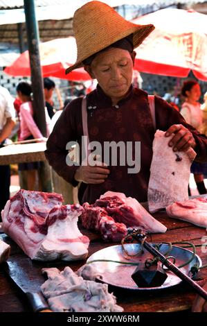 Ein Fleischverkäufer auf einem Wochenmarkt im Süden der Provinz Yunnan, China. Stockfoto