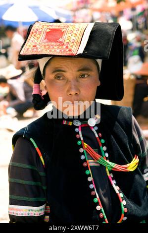 Stammesfrau auf einem geschäftigen Markt in der Provinz Yunnan, China. Stockfoto