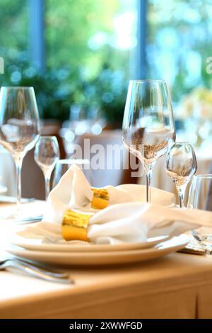 Tisch in einem Restaurant. Leere Gläser stehen im Restaurant. Tischaufstellung mit Gläsern, Besteck und Tellern. Inneneinrichtung des Restaurants. Stockfoto