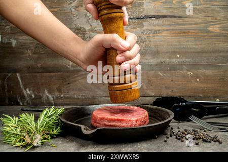 Eine Person mahlt Filet mit einer Pfeffermühle Stockfoto