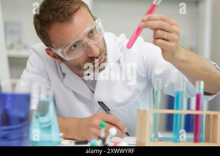 Männliche Wissenschaftler untersuchen Reagenzglas Stockfoto