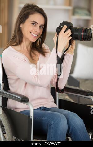 Porträt einer Frau im Rollstuhl mit Kamera Stockfoto