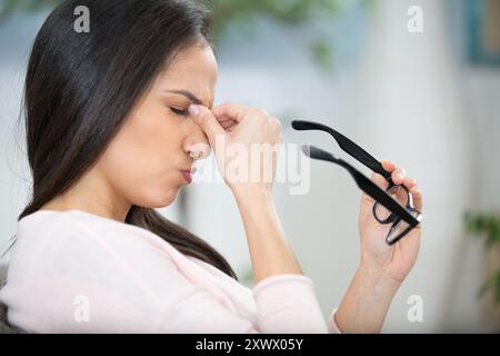 Müde Geschäftsfrau hält Brillen leiden Augenschmerzen Stockfoto