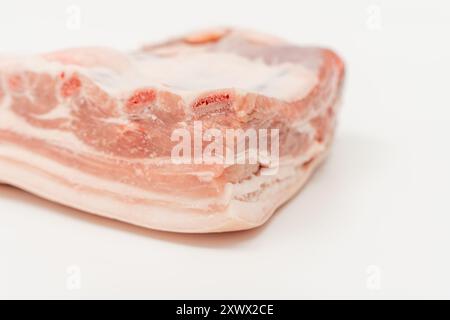 Ein Stück Fleisch mit weißem Hintergrund. Das Fleisch wird in zwei Hälften geschnitten und hat eine rosafarbene Farbe Schweinefleisch isoliert auf weißem Hintergrund. Stockfoto