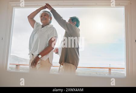 Altes Paar, tanzen und fröhliches Lachen zu Hause, Wochenendromane und Date im Ruhestand aus Liebe. Senioren, die Hände halten und sich für die Verbindung verbinden Stockfoto