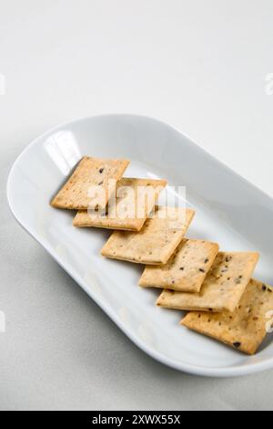 Sauerteig-Cracker, Brown Rice Cracker, hausgemachte Cracker mit Samen auf weißer Schüssel Nahaufnahme. Stockfoto