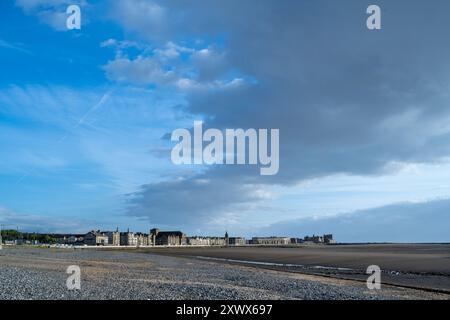 Dieses ruhige Bild fängt die Küstenstadt Morecambe mit ihren historischen Gebäuden an der Küste der Morecambe Bay ein. Der weitläufige Himmel und der Kiesstrand bieten eine ruhige und malerische Umgebung, die perfekt ist, um die Schönheit der Küste zu zeigen. Stockfoto
