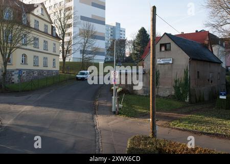 Eine ruhige Wohnstraße in Freital, Sachsen, mit einer Mischung aus historischer und moderner Architektur. Das Bild fängt die friedliche Atmosphäre der Gegend mit ein paar geparkten Autos und minimalistischen urbanen Elementen ein. Ideal zur Darstellung des städtischen Lebens in kleinen deutschen Städten. Stockfoto