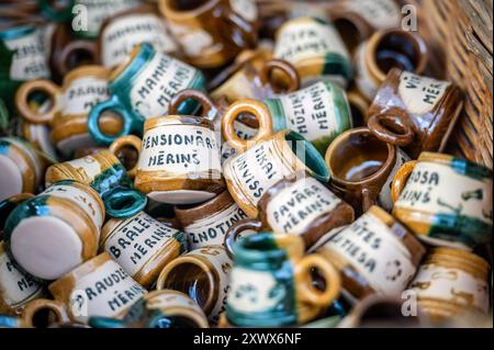 Jaunpils, Lettland - 10. August 2024: Eine Sammlung von Keramikbechern mit einzigartigen handgeschriebenen Etiketten. Stockfoto