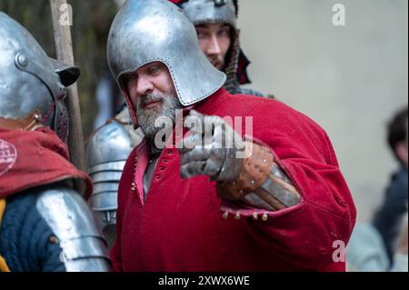 Jaunpils, Lettland – 10. August 2024: Die Teilnehmer nehmen an einer Nachstellung in mittelalterlicher Rüstung Teil. Stockfoto