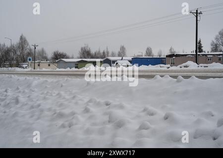 Ein verschneite Wohnwagenpark in Anchorage, Alaska, zeigt eine kalte und ruhige Winterszene. Das ruhige Bild fängt die Stille und Ruhe der Gegend ein und spiegelt Widerstandsfähigkeit und Einfachheit bei rauem Wetter wider. Stockfoto