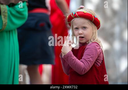 Jaunpils, Lettland - 10. August 2024: Ein junges Mädchen posiert mit Neugier auf einem festlichen Kulturereignis. Stockfoto