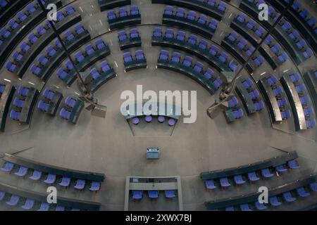 Dieses Bild zeigt eine Luftaufnahme des Plenarsaals im Berliner Bundestag. Die moderne Architektur, die kreisförmige Sitzanordnung und die Designelemente zeigen die Bedeutung des Ortes in der deutschen Politik. Stockfoto