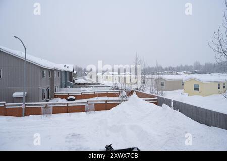 Schneebedeckte Landschaft mit Wohnmobilen in einem Wohnwagenpark in Anchorage, Alaska. Die ruhige Szene kann metaphorisch Widerstandskraft und die ruhige Schönheit des Winters symbolisieren. Stockfoto