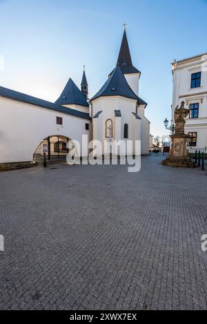 Kostel Povyseni sv. Krize-Kirche mit Statue des heiligen Patrick in der Stadt Karvina in Tschechien an einem schönen Tag mit klarem Himmel Stockfoto