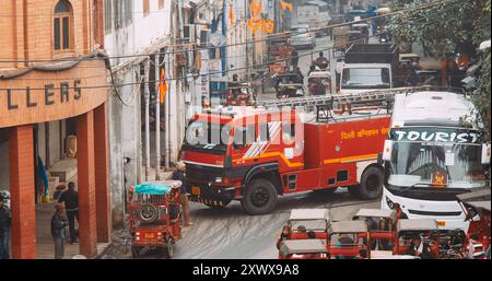 Neu-Delhi, Delhi, Indien. Ein Feuerwehrauto fährt morgens auf die Straße in der Nähe des Bazar Paiwalan Jama Masjid Bazar Gulian Hippy Wada Chandni Chowk. Autos Stockfoto