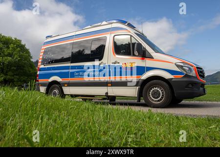 Oberstdorf, Deutschland. August 2024. Ein Krankenwagen vom Arbeiter-Samariter-Bund (ASB) fährt an der Alpe Dornach vorbei. Das ASB transportiert behandlungsbedürftige Patienten unter dem Motto „Dare to make Last wishes“ an besondere Orte, um ihre letzten Wünsche zu erfüllen und besondere Erlebnisse zu ermöglichen. Quelle: Stefan Puchner/dpa/Alamy Live News Stockfoto