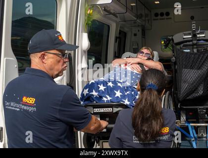 Oberstdorf, Deutschland. August 2024. Norbert Rzadki (l) und Rima Schucht (r) vom Arbeiter-Samariter-Bund (ASB) laden Kerstin Lindemann, die auf einer Liege liegt, in einen Krankenwagen auf der Alpe Dornach. Unter dem Motto „Dare to make Last wishes“ transportiert die ASB Patienten, die sich einer Behandlung unterziehen, an besondere Orte, um ihre letzten Wünsche zu erfüllen und besondere Erlebnisse zu ermöglichen. Quelle: Stefan Puchner/dpa/Alamy Live News Stockfoto